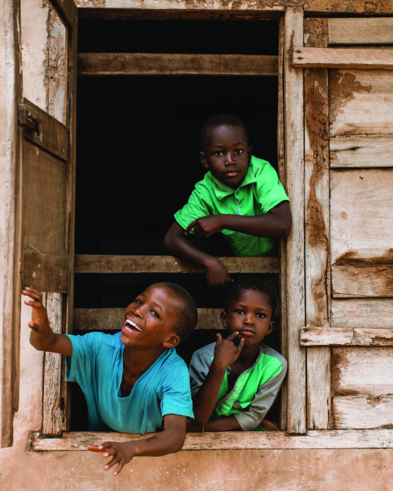 Children peering through a wooden window