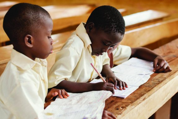 School children writing in notebooks